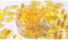 A jar full of fast yellow fish oil capsules to be avoided during liposuction.