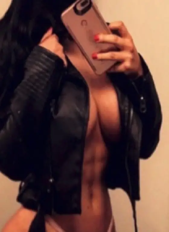 Person taking a mirror selfie wearing a black jacket and holding a phone, partially covering their face.